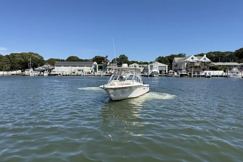 Slide: The Image of 2013 Grady-White Freedom 255 boat cruising in a scenic marina setting. - 1