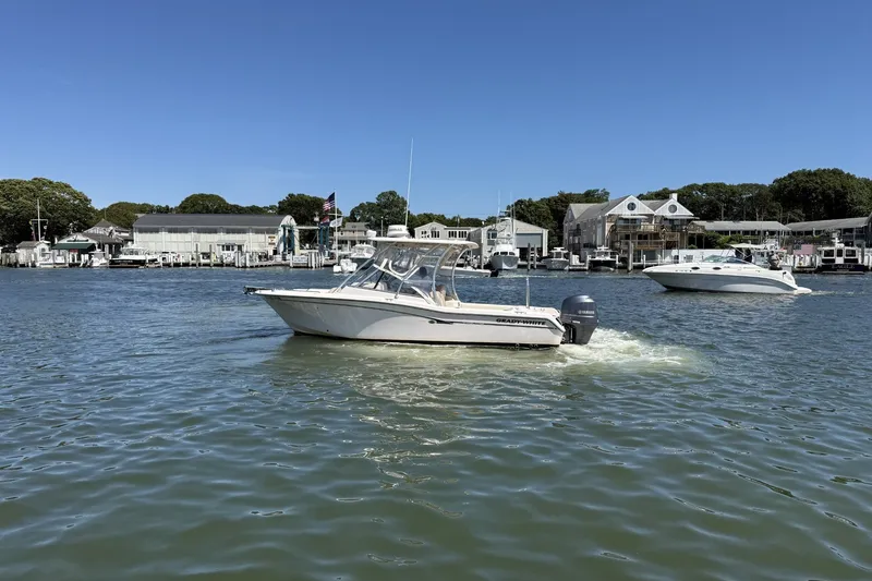 Slide: The Image of 2013 Grady-White Freedom 255 boat cruising in a scenic marina setting. - 6