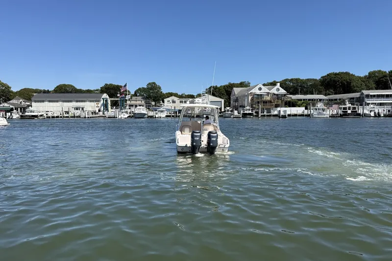 Slide: The Image of 2013 Grady-White Freedom 255 boat cruising in a scenic harbor setting. - 8