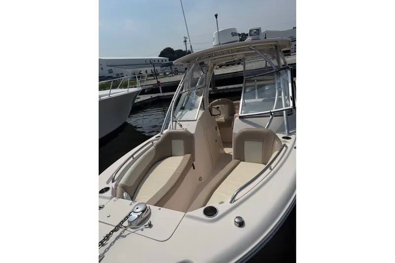 Slide: The Image of 2013 Grady-White Freedom 255 boat with beige seating, docked at a marina. - 13