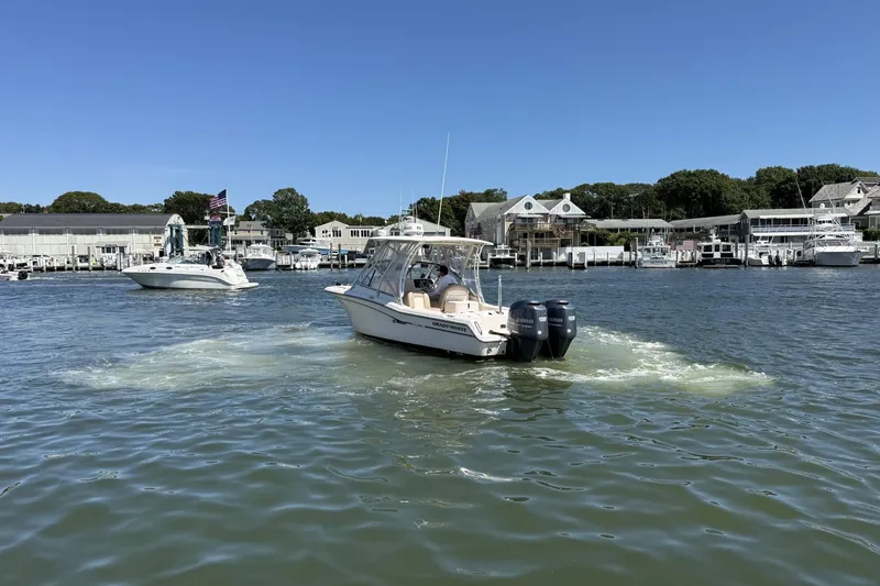 Slide: The Image of 2013 Grady-White Freedom 255 boat cruising in a marina under clear blue skies. - 7