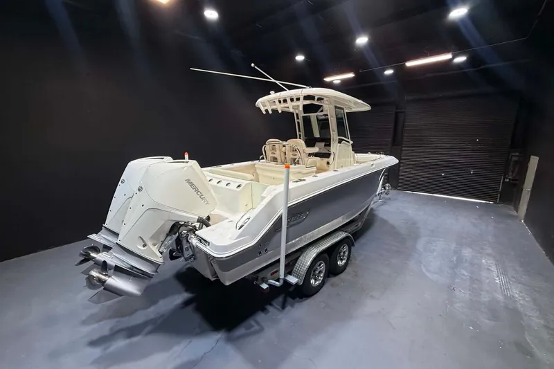 Slide: The Image of 2022 Boston Whaler 250 Outrage boat in a dimly lit indoor setting. - 5