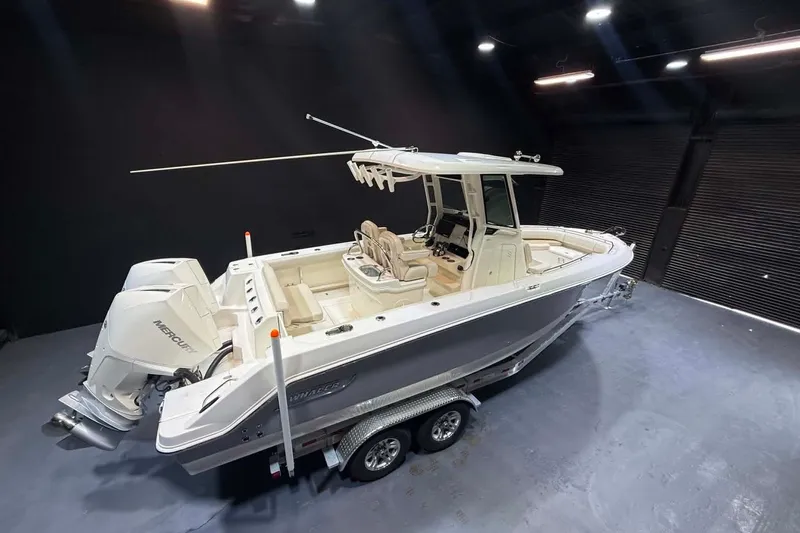 Slide: The Image of 2022 Boston Whaler 250 Outrage boat with dual Mercury engines in a showroom. - 3
