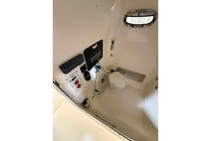 Slide: The Image of Interior of 2022 Boston Whaler 250 Outrage boat featuring a compact marine toilet. - 18