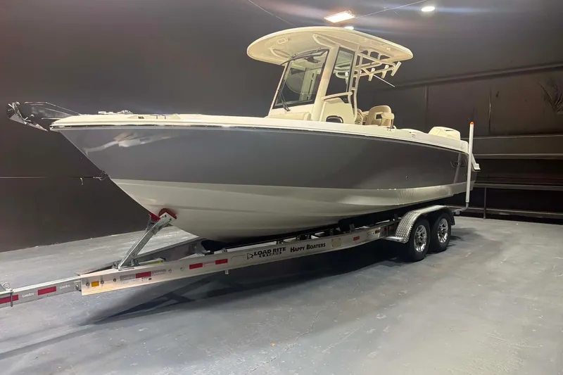 Slide: The Image of 2022 Boston Whaler 250 Outrage boat on trailer in indoor setting. - 2