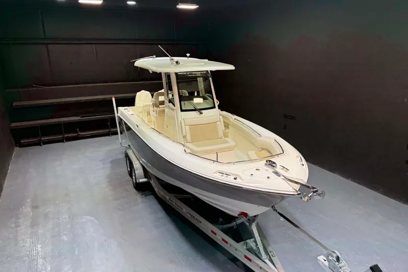 Slide: The Image of 2022 Boston Whaler 250 Outrage boat on trailer in indoor setting. - 10