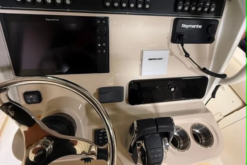 Slide: The Image of 2022 Boston Whaler 250 Outrage dashboard with steering wheel, controls, and Raymarine electronics. - 16