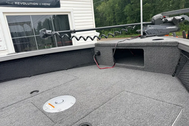 Slide: The Image of 2027 Crestliner 1850 Kodiak SC boat deck with Lowrance equipment, gray carpeting, and storage compartment. - 7