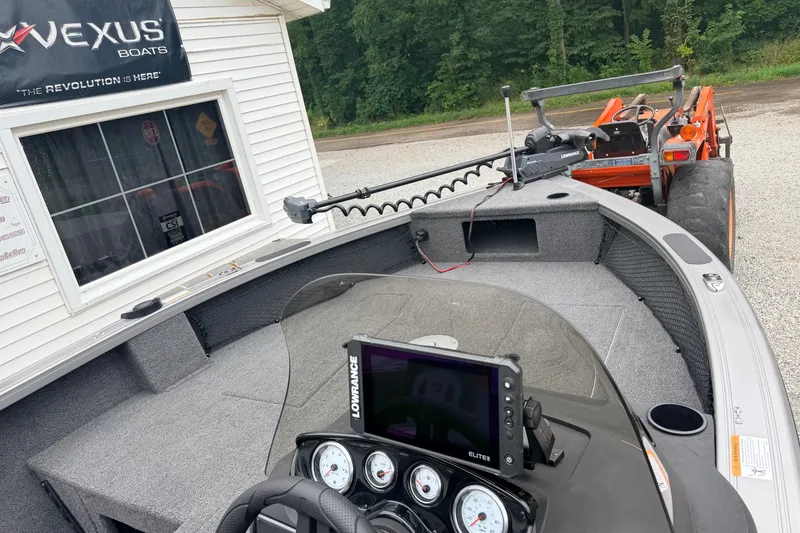 Slide: The Image of Crestliner 1850 Kodiak SC boat interior with Lowrance electronics, parked near Vexus Boats dealership. - 6