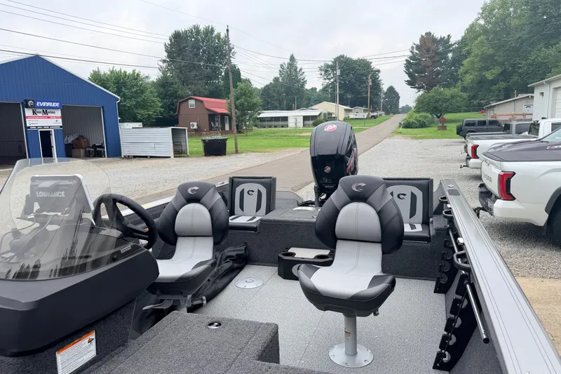 Slide: The Image of 2027 Crestliner 1850 Kodiak SC boat with seating and steering console, parked outdoors. - 9