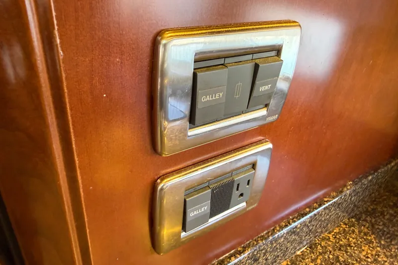 Slide: The Image of Switches and outlet on 2005 Sea Ray 48 Sundancer yacht's wooden panel. - 74