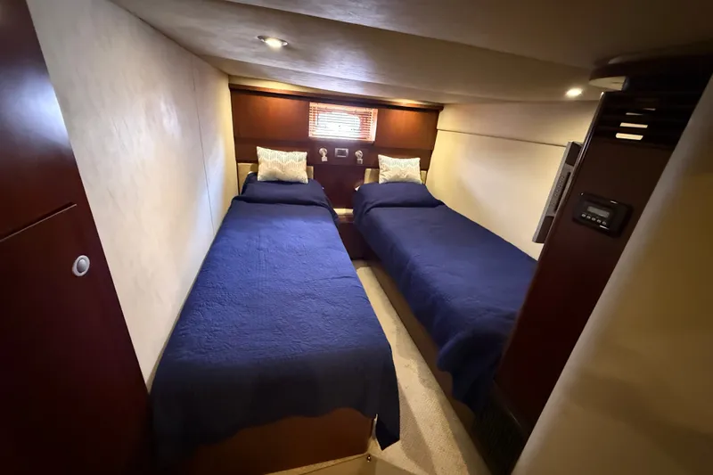 Slide: The Image of Interior cabin of 2005 Sea Ray 48 Sundancer with twin beds and blue bedding. - 95