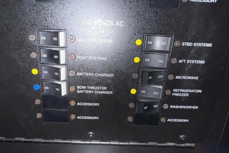Slide: The Image of Electrical panel of a 2005 Sea Ray 48 Sundancer yacht with labeled switches. - 104
