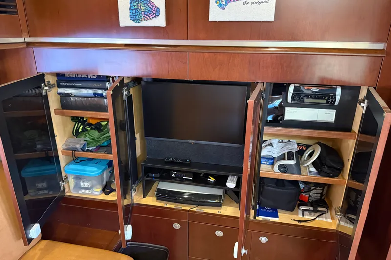 Slide: The Image of 2005 Sea Ray 48 Sundancer interior with entertainment center and storage cabinets. - 84