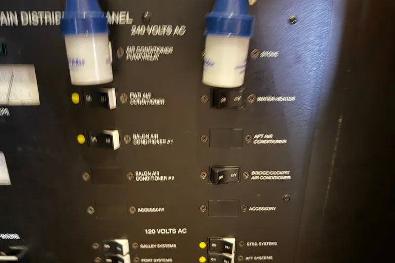 Slide: The Image of Electrical panel of a 2005 Sea Ray 48 Sundancer boat, showing various switches. - 103