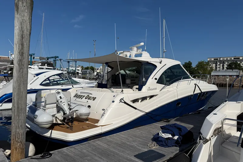 Slide: The Image of 2005 Sea Ray 48 Sundancer yacht docked at marina under clear blue sky. - 1