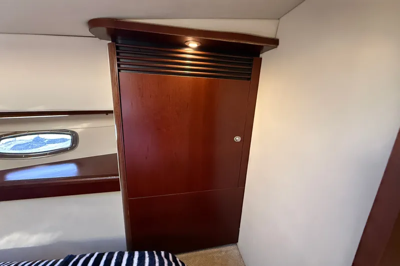 Slide: The Image of Interior of 2005 Sea Ray 48 Sundancer with wooden cabinet and porthole window. - 49
