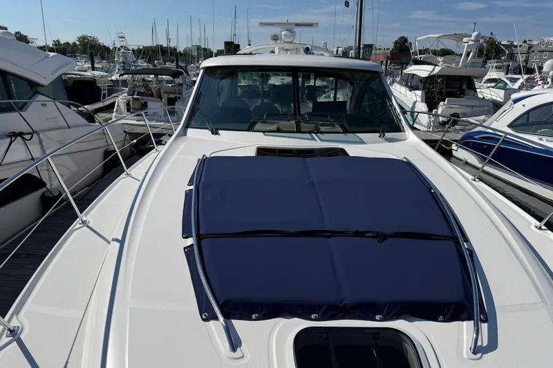 Slide: The Image of 2005 Sea Ray 48 Sundancer yacht docked at marina, featuring sleek design and blue cover. - 23