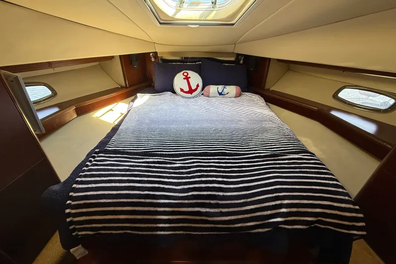 Slide: The Image of Luxurious cabin interior of 2005 Sea Ray 48 Sundancer with nautical-themed bedding. - 48