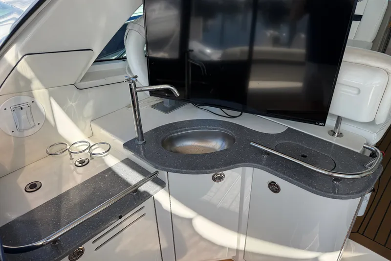 Slide: The Image of 2005 Sea Ray 48 Sundancer yacht interior with sink, countertop, and mounted TV. - 16