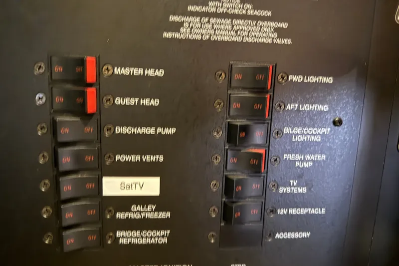 Slide: The Image of Electrical panel of a 2005 Sea Ray 48 Sundancer yacht with labeled switches. - 102