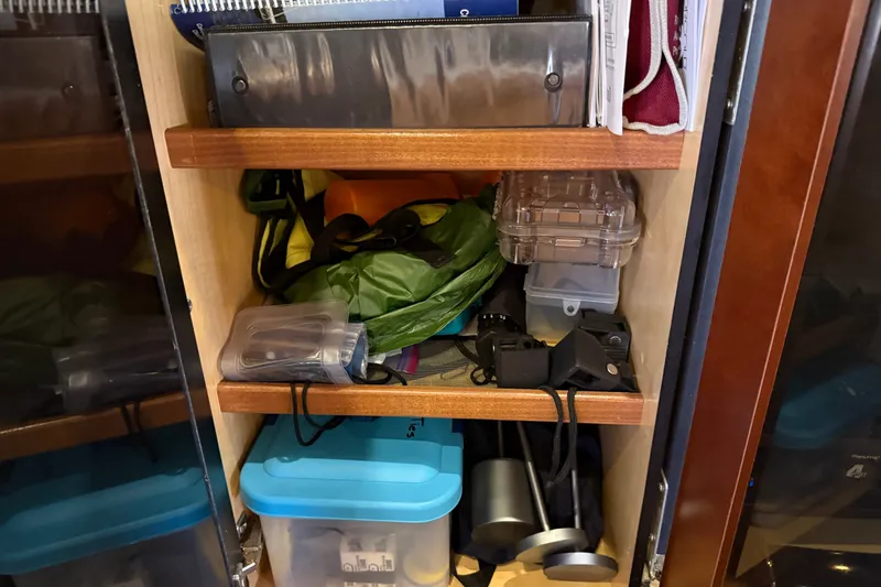 Slide: The Image of Storage shelves on a 2005 Sea Ray 48 Sundancer, filled with various boating equipment. - 86