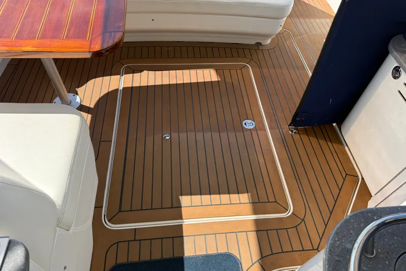 Slide: The Image of 2005 Sea Ray 48 Sundancer cockpit with teak flooring and seating area. - 43