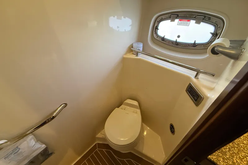 Slide: The Image of Compact bathroom in 2005 Sea Ray 48 Sundancer yacht with toilet and porthole window. - 92