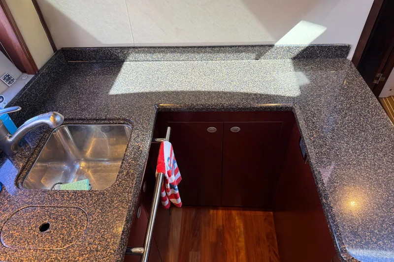 Slide: The Image of 2005 Sea Ray 48 Sundancer kitchen with granite countertop and stainless steel sink. - 77