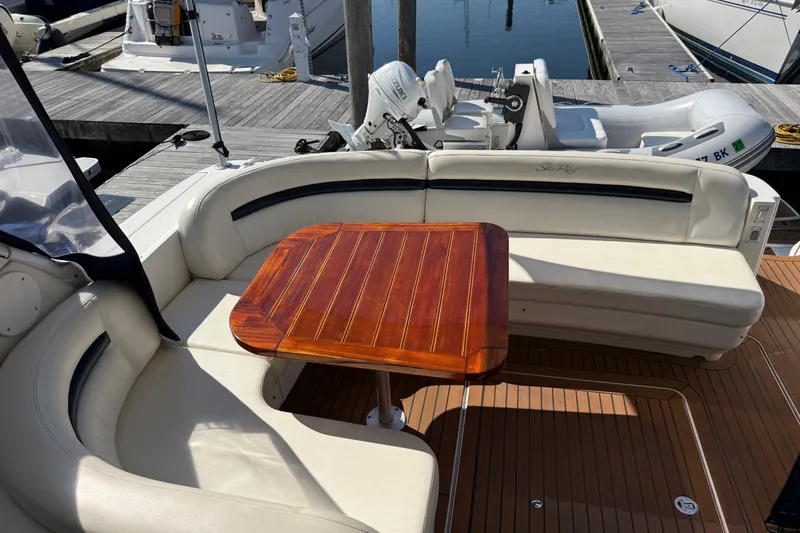 Slide: The Image of 2005 Sea Ray 48 Sundancer yacht with elegant seating and wooden table on deck. - 11