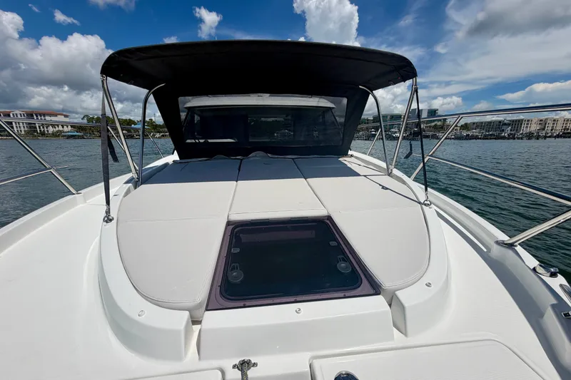Slide: The Image of 2026 Beneteau Antares 11 boat with sun deck, canopy, and scenic waterfront view. - 26