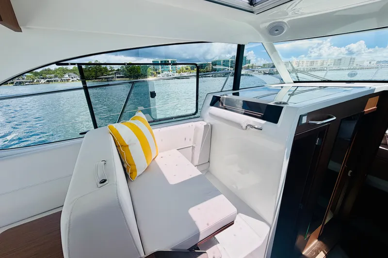 Slide: The Image of Interior of 2026 Beneteau Antares 11 yacht with scenic water view and striped cushion. - 21