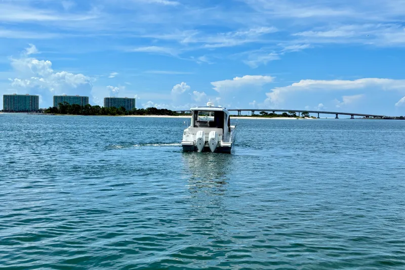 Slide: The Image of 2026 Beneteau Antares 11 cruising on a sunny day near a bridge and buildings. - 6