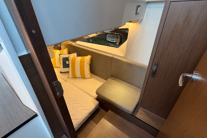 Slide: The Image of Interior of 2026 Beneteau Antares 11, featuring cozy seating and decorative pillows. - 33