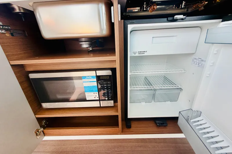 Slide: The Image of Compact kitchen area in 2026 Beneteau Antares 11 with microwave and fridge. - 16