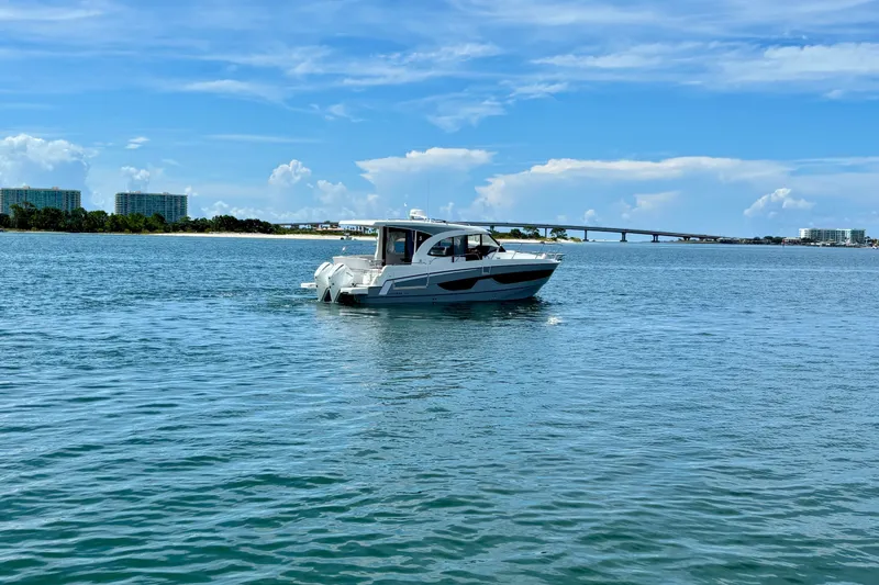 Slide: The Image of 2026 Beneteau Antares 11 cruising on a sunny day near a coastal bridge. - 7
