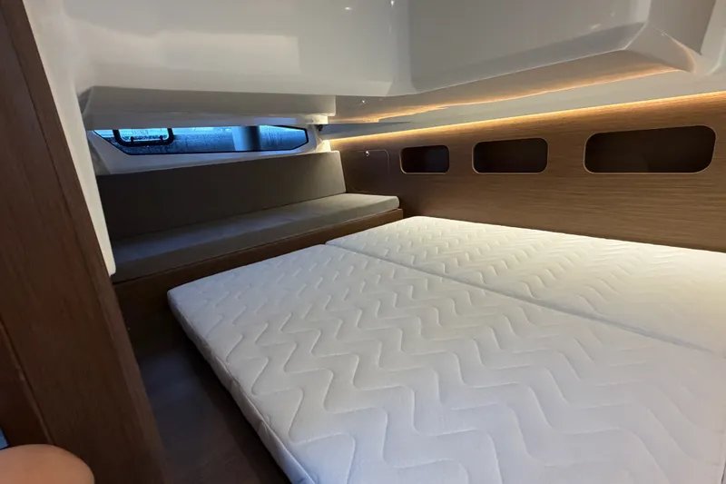 Slide: The Image of Interior cabin of 2026 Beneteau Antares 11 with modern bedding and ambient lighting. - 35