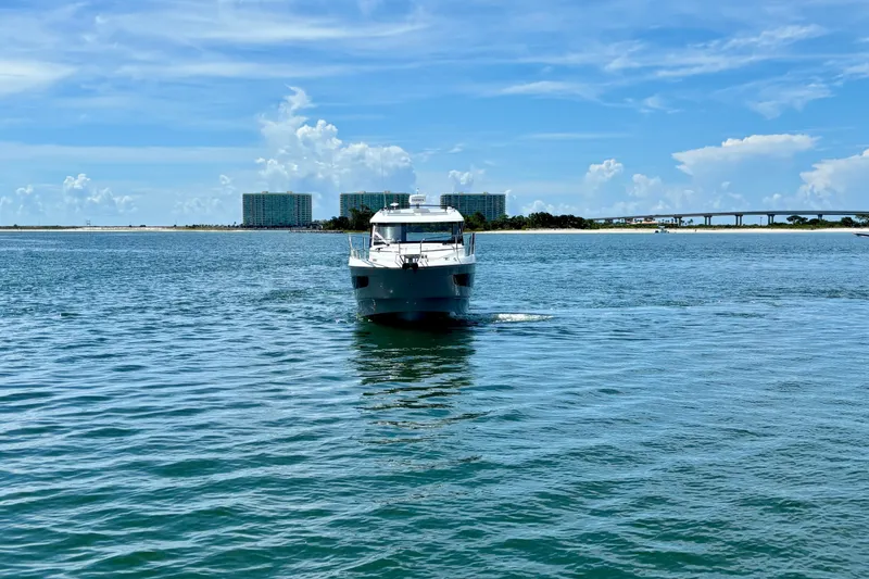 Slide: The Image of 2026 Beneteau Antares 11 cruising on a sunny day with a scenic coastal backdrop. - 2