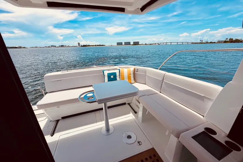 Slide: The Image of 2026 Beneteau Antares 11 boat interior with seating, table, and ocean view. - 9