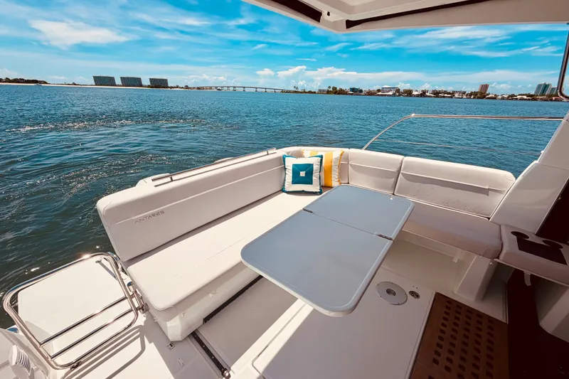Slide: The Image of 2026 Beneteau Antares 11 boat deck with seating and table, overlooking serene waters. - 8