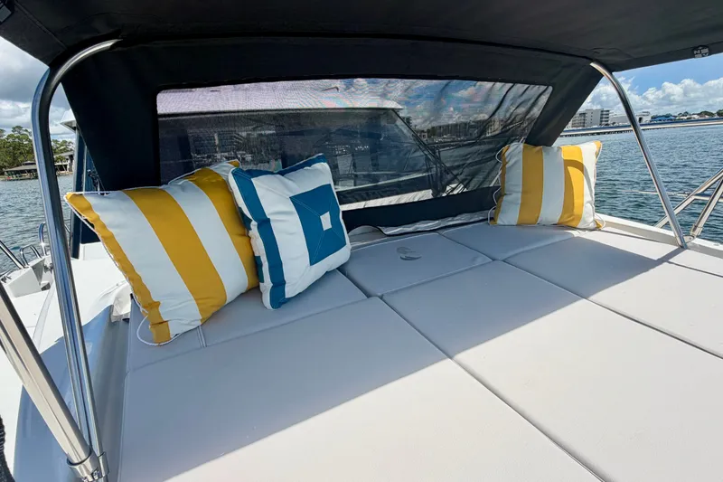 Slide: The Image of 2026 Beneteau Antares 11 boat deck with striped cushions, overlooking serene waters. - 24
