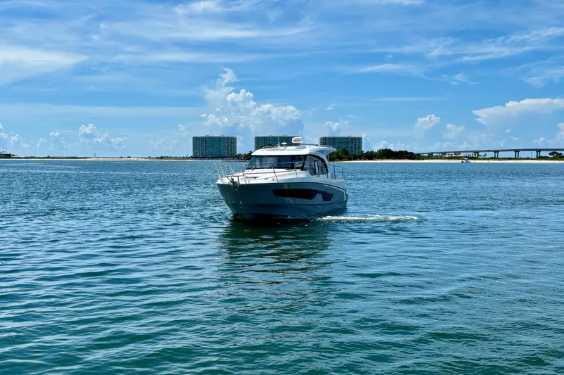 Slide: The Image of 2026 Beneteau Antares 11 cruising on a sunny day with a scenic backdrop. - 3
