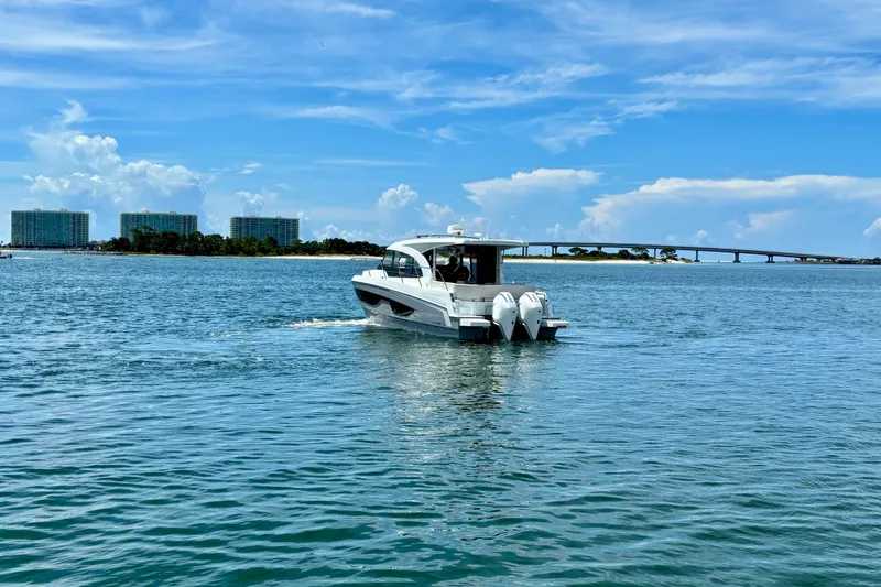 Slide: The Image of 2026 Beneteau Antares 11 cruising on a sunny day near a bridge and buildings. - 5