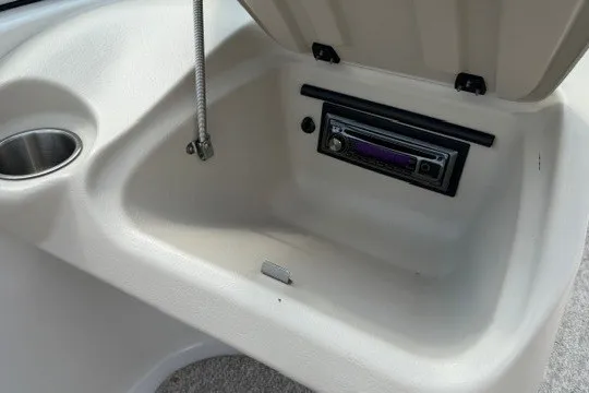 Slide: The Image of 2011 Glastron GT 205 boat storage compartment with built-in stereo system. - 22