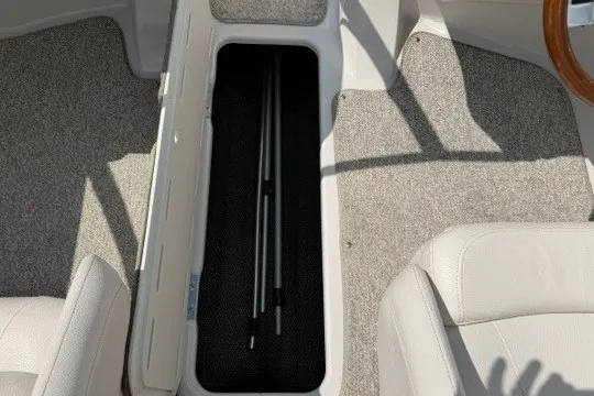 Slide: The Image of 2011 Glastron GT 205 boat interior with open storage compartment and carpeted flooring. - 18