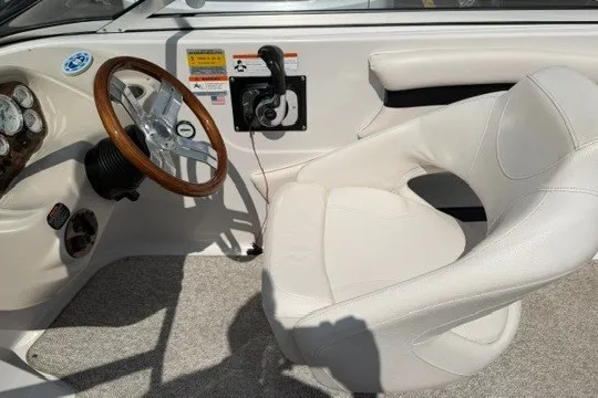 Slide: The Image of 2011 Glastron GT 205 boat interior with steering wheel and white captain's chair. - 16