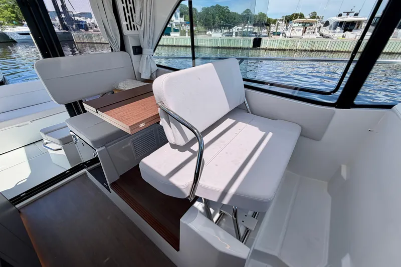 Slide: The Image of Interior of 2026 Beneteau Antares 9 boat with seating and table, dockside view. - 15