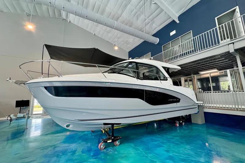 Slide: The Image of 2026 Beneteau Antares 9 boat displayed indoors on a blue floor. - 34