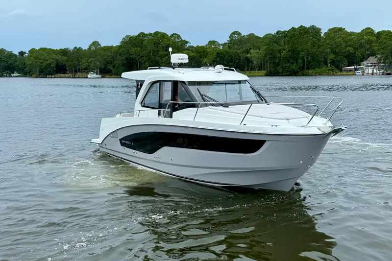 Slide: The Image of 2026 Beneteau Antares 9 cruising on a serene lake with lush green trees. - 6
