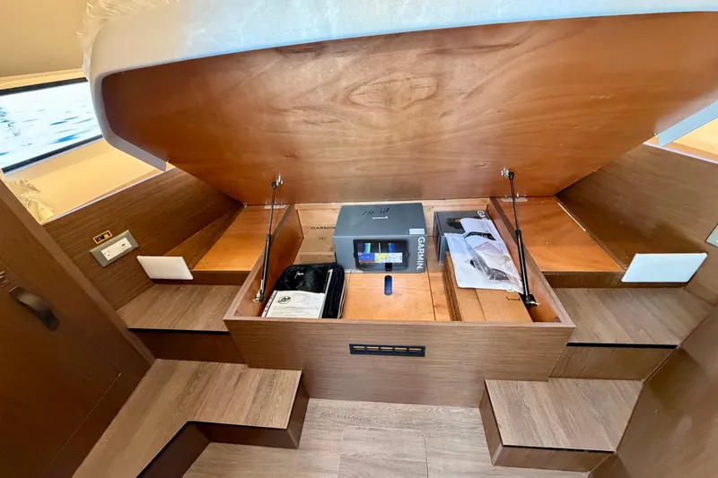 Slide: The Image of 2026 Beneteau Antares 9 interior storage compartment with wooden finish and equipment. - 20